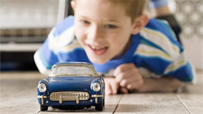 Photo of a boy playing with a toy car