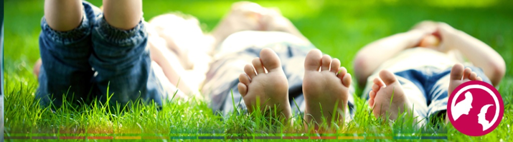 Kids laying in the grass barefoot.