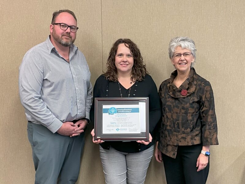 Employees holding up certificate