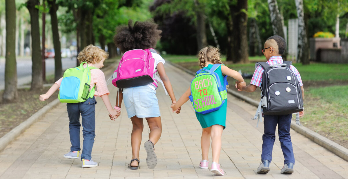 small school children with colorful school bags and backpacks run to school. Back to school, education, elementary school.